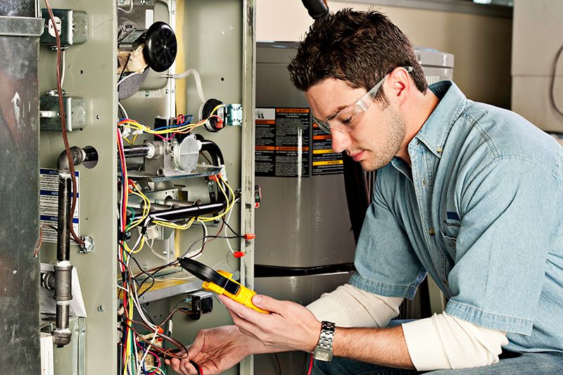 Image of technician working with AC unit. Why Do I Need AC Maintenance Now?