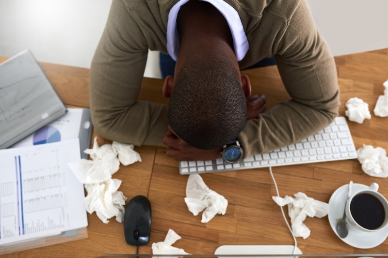 High angle shot of a young businessman feeling ill at his work desk.