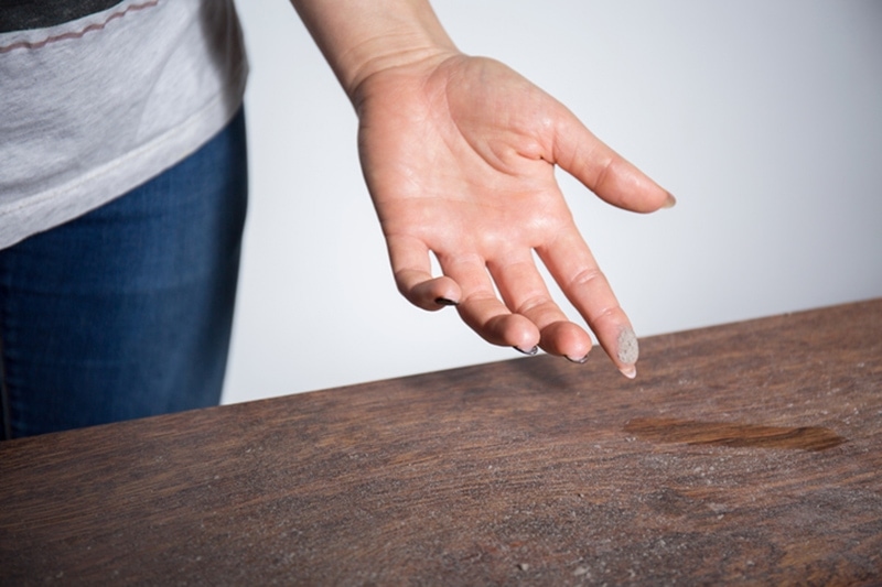 How to Reduce Dust in Your Home. Close-up of dust on woman finger.