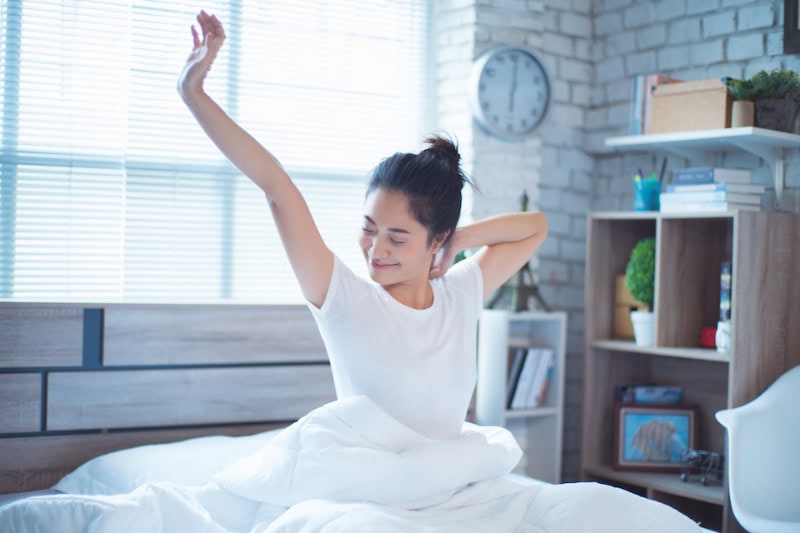 woman in bed and was waking up in the morning. She felt very refreshed.