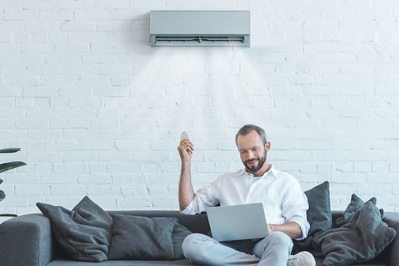 Video - 4 Amazing Benefits of Ductless Units - Man Sitting Under Ductless AC Unit.