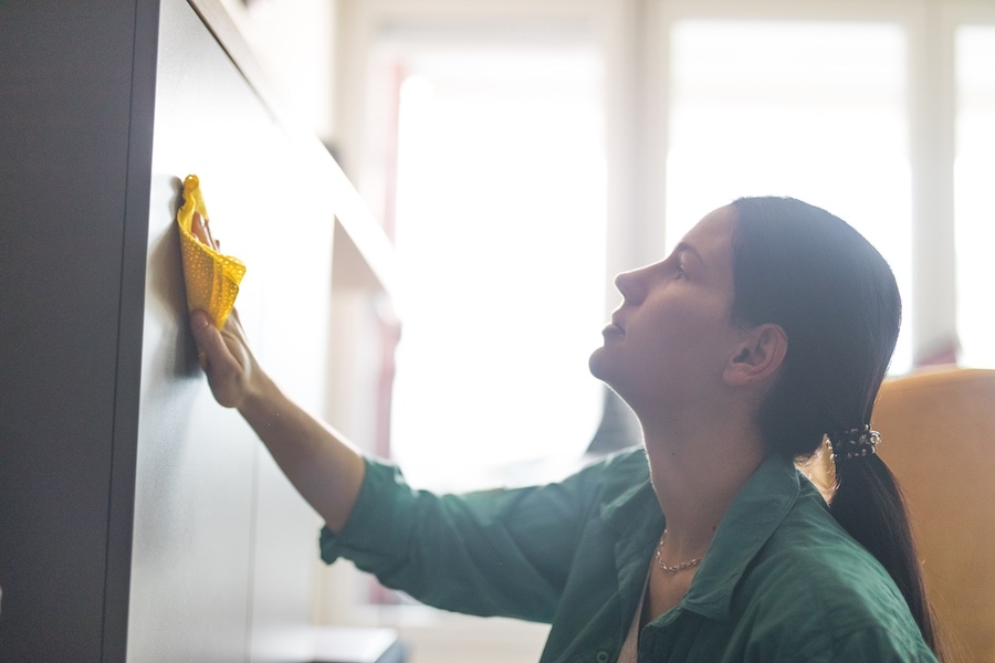 Cutting-Edge Technology Kills Airborne Viruses. Woman polishing furniture in the living room.